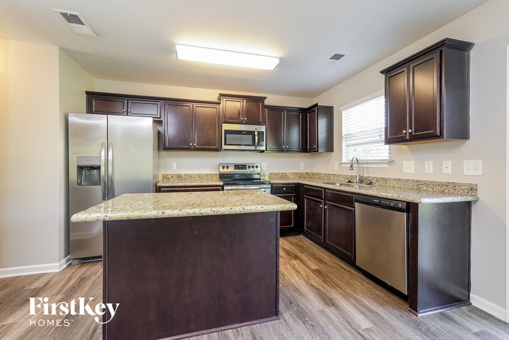 A kitchen with a granite countertop and stainless steel appliances.