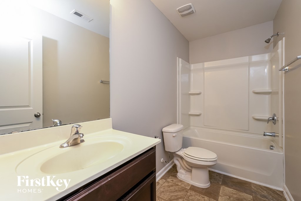 A bathroom with a sink, toilet, and bathtub.