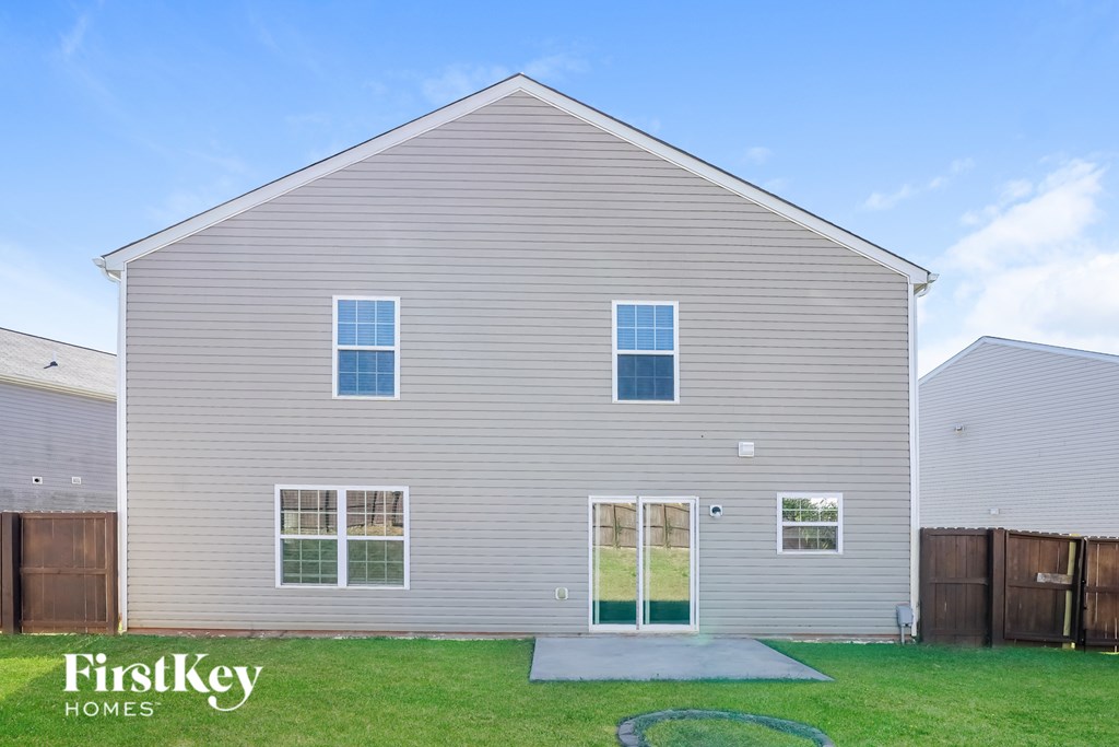 A grey house with a green door and windows.