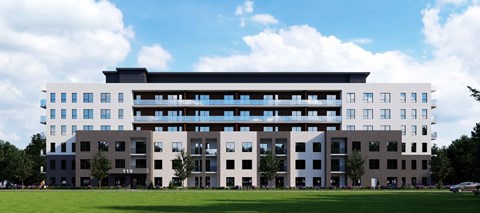 A large, modern building with a flat roof and a mix of white and grey exterior walls.