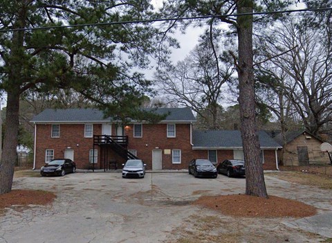 A house with a driveway and cars parked in front.