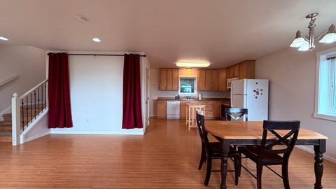 A dining room with a table and chairs.