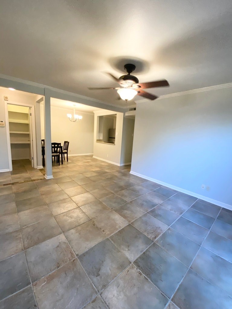 A room with a ceiling fan and tile flooring.