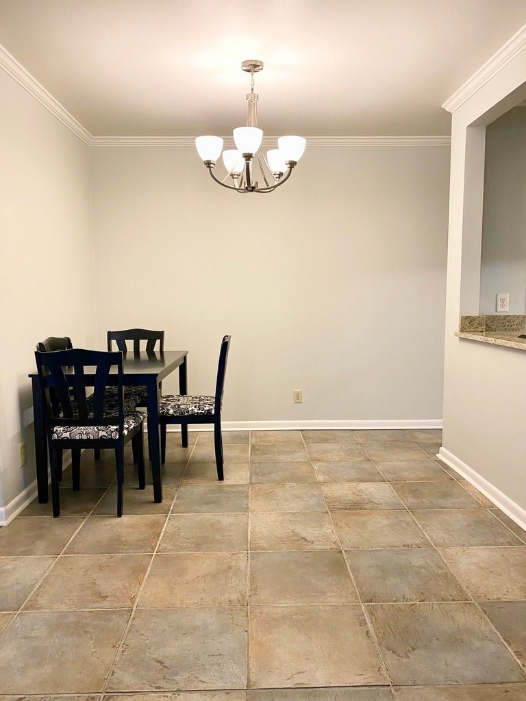 A dining room with a table and chairs.