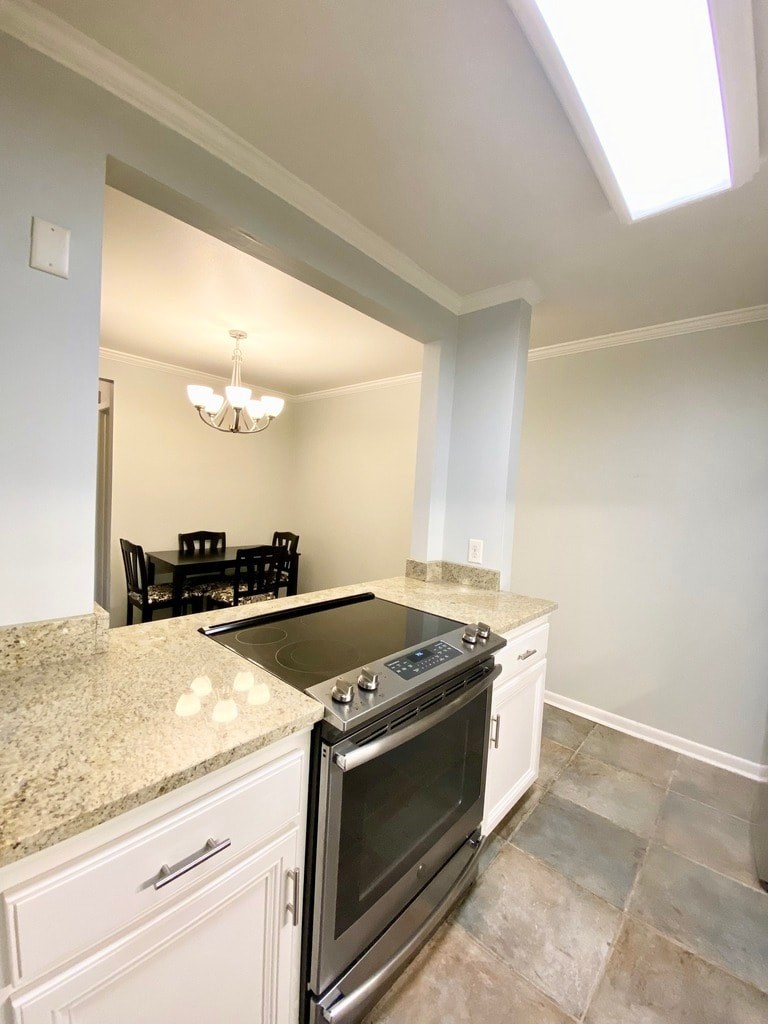 A kitchen with a granite countertop and a stove top oven.