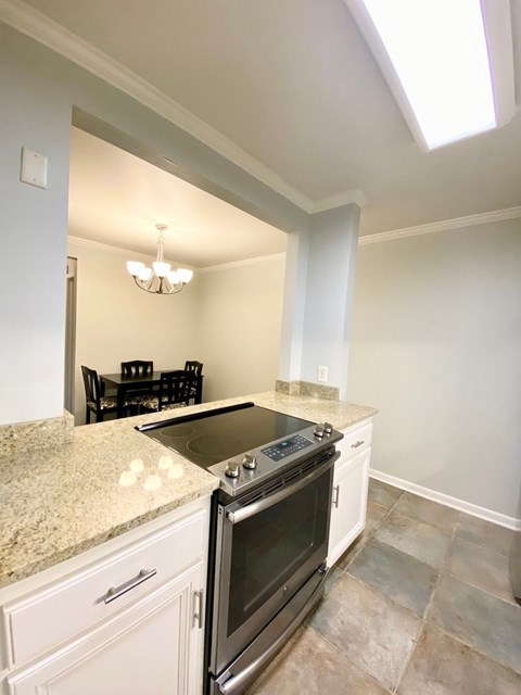 A kitchen with a granite countertop and a stove top oven.