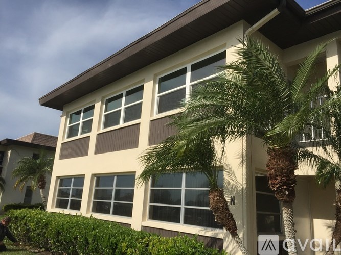 A house with a brown roof and a palm tree in front.