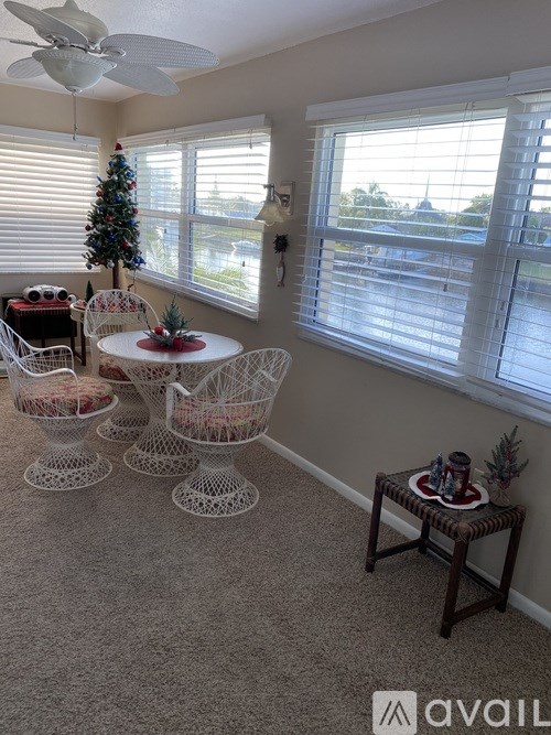 A living room with a Christmas tree and a fan.