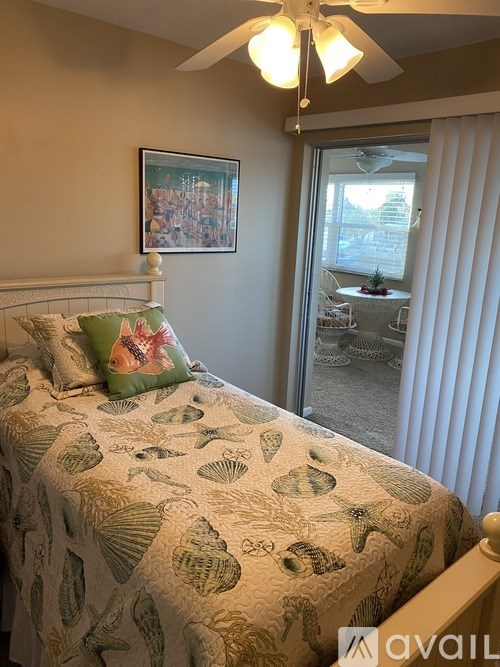 A bedroom with a bed covered in a shell patterned comforter.