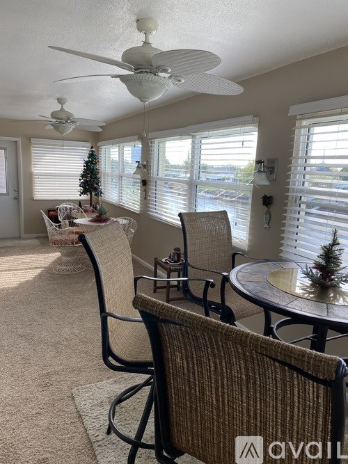 A living room with a Christmas tree and a fan.