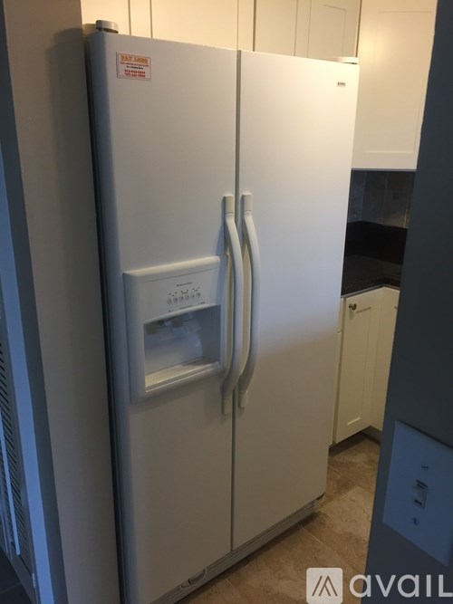 A white fridge with a sticker on the door.