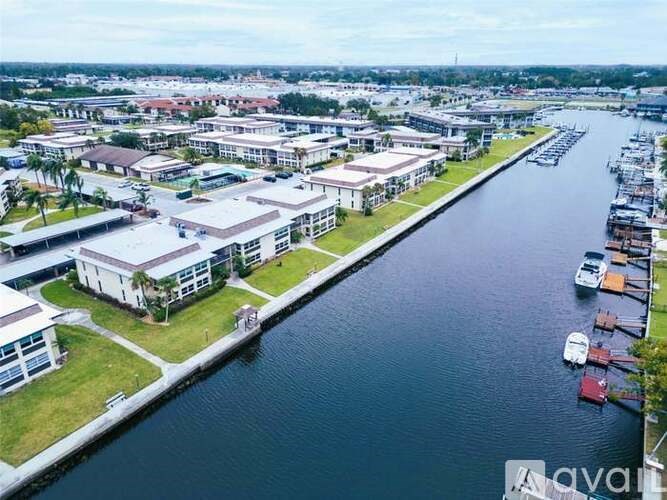 A marina with boats docked and buildings alongside a body of water.