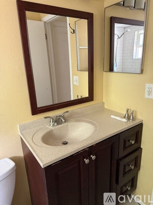 A bathroom with a sink, mirror, and toilet.