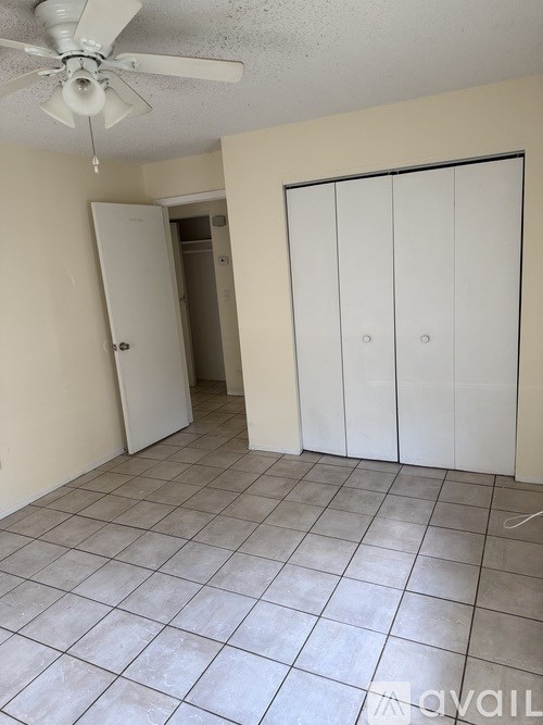 A room with a ceiling fan and a door.