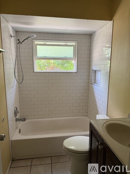 A bathroom with a tub, toilet, and sink.