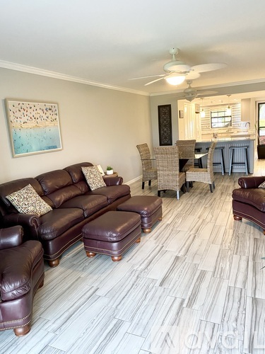A living room with a brown leather couch and matching ottoman.