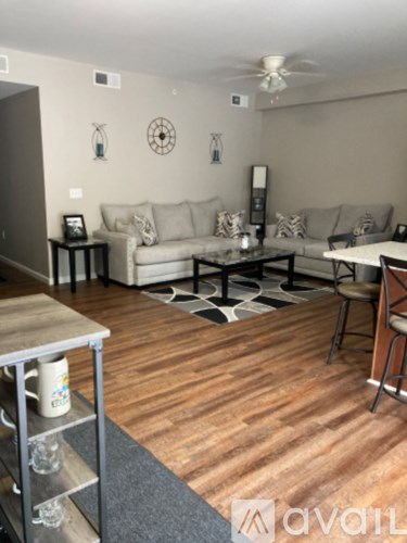 A living room with a couch, a coffee table, and a ceiling fan.