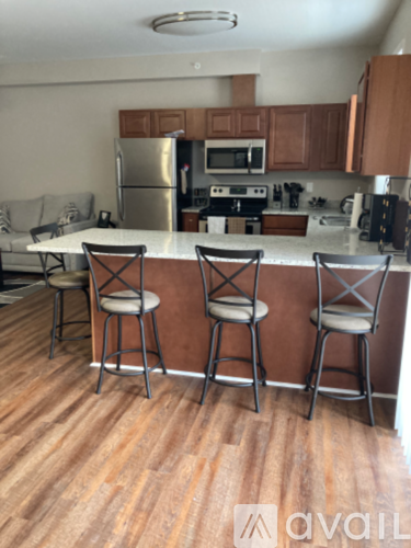 A kitchen with a bar stool in front of the counter.