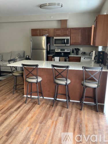 A kitchen with a bar stool in front of the counter.