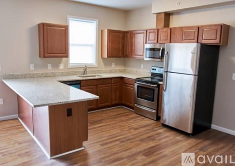 A kitchen with wooden cabinets and a stainless steel refrigerator.