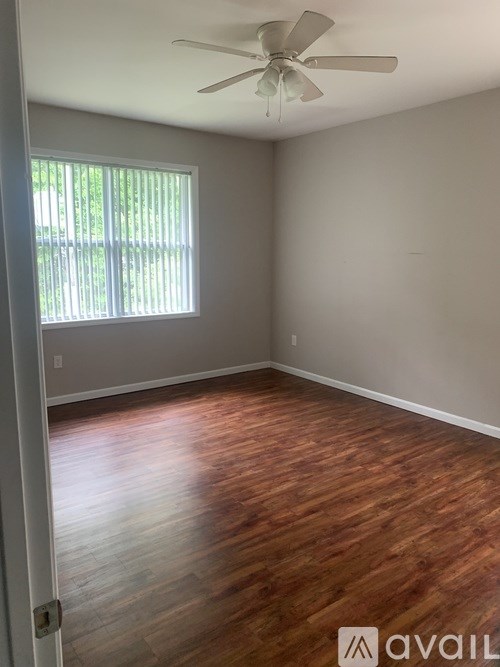A room with wooden floors and a ceiling fan.