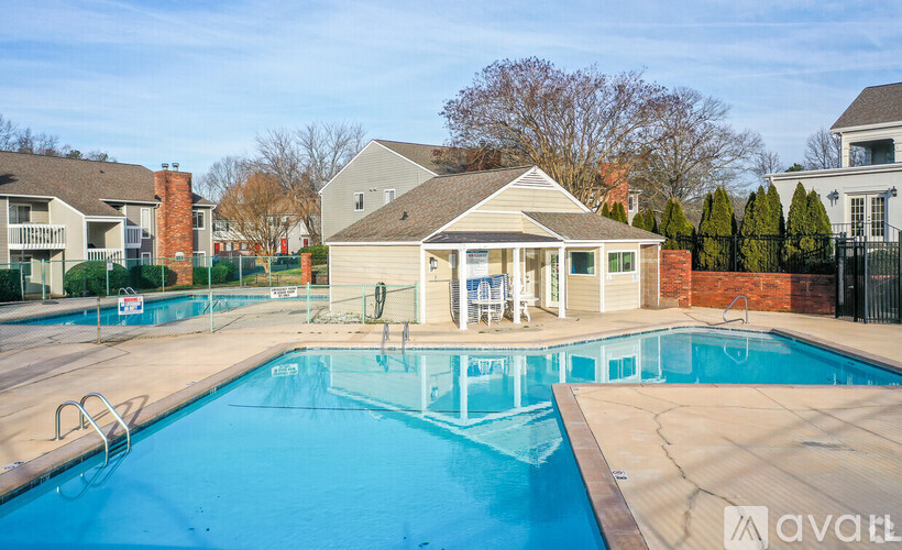 A swimming pool in front of a house with a sign that says "avail".