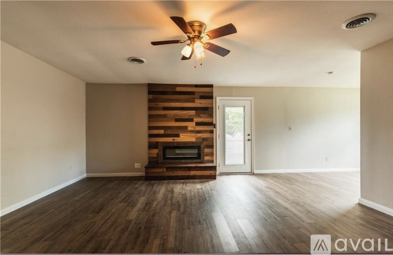 A room with a wooden floor and a ceiling fan.