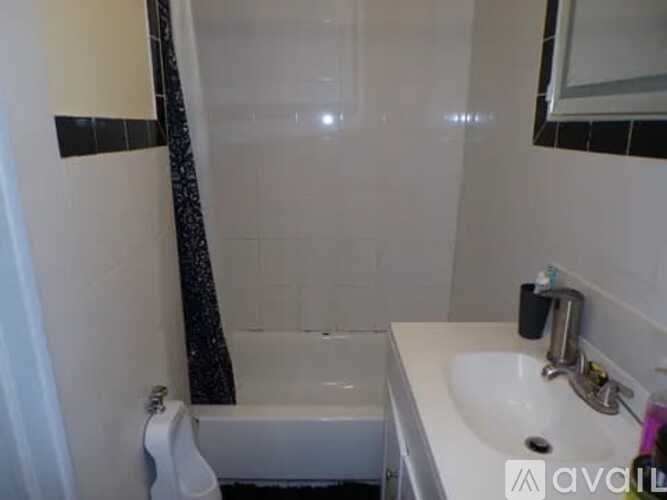 A white sink is on a counter next to a white bathtub.