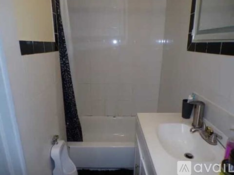 A white sink is on a counter next to a white bathtub.