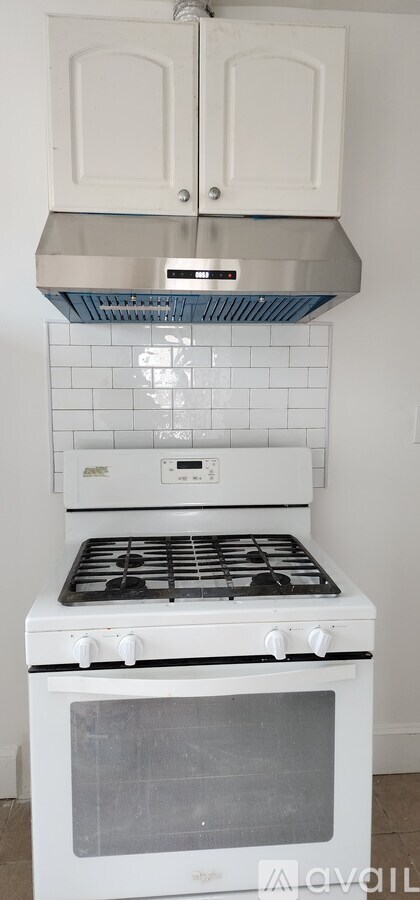 A white oven with a stainless steel hood above it.