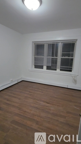 A room with a window and wooden flooring.