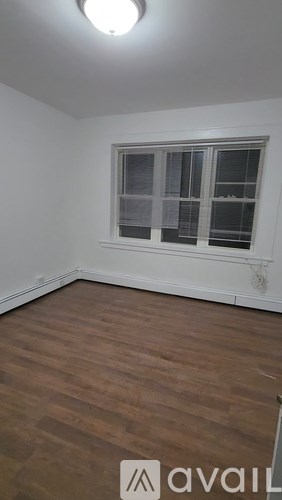 A room with a window and wooden flooring.