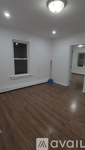 A room with a broom and a window.