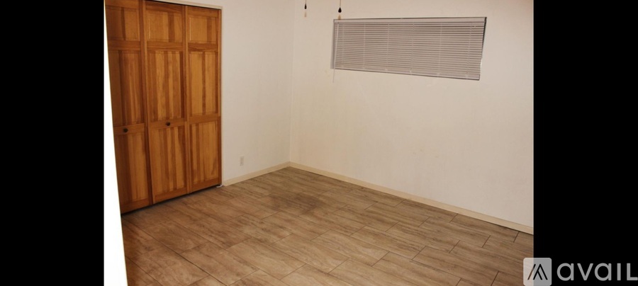 A room with a wooden door and a window with blinds.