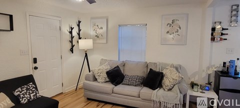 A living room with a grey couch and a black chair.