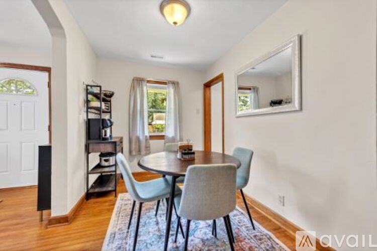 A dining room with a round table and chairs.