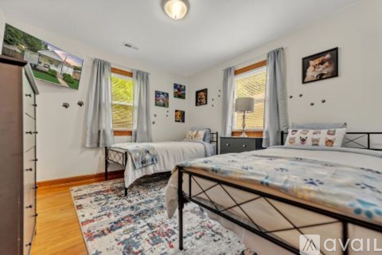 A bedroom with two beds and a rug on the floor.
