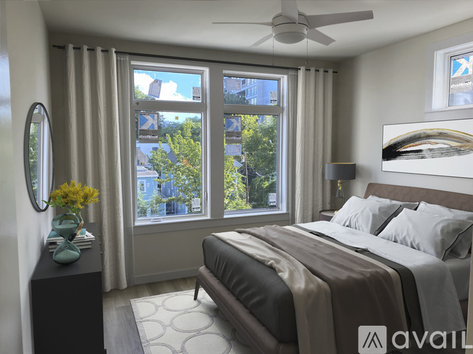 A bedroom with a large bed and a view of the city through the window.