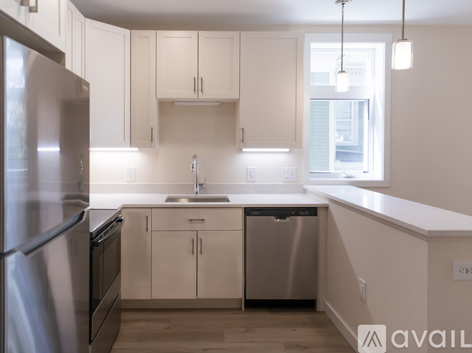 A modern kitchen with white cabinets and stainless steel appliances.