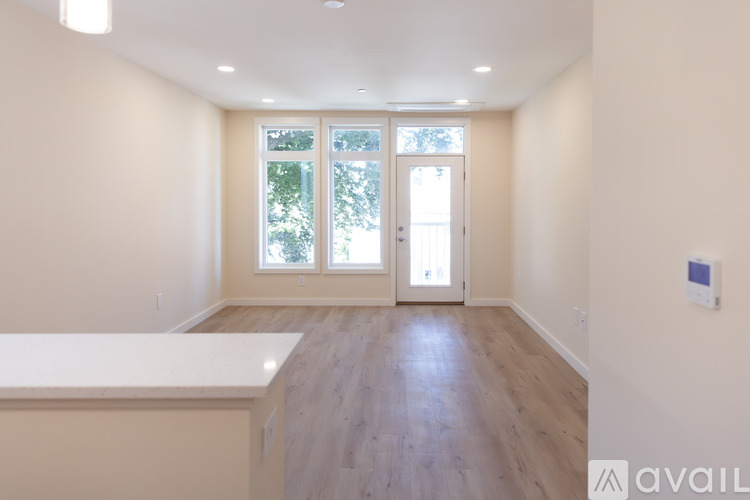 A room with a white counter and wooden floors.