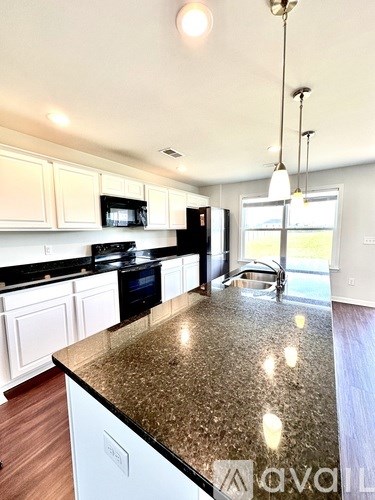 A kitchen with granite countertops and white cabinets.