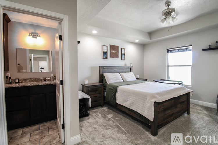 A bedroom with a large bed and a vanity with a mirror.