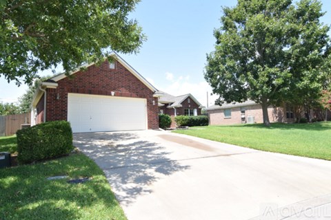 A red brick house with a white garage door.