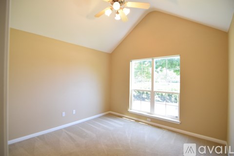 A room with a ceiling fan and a window.
