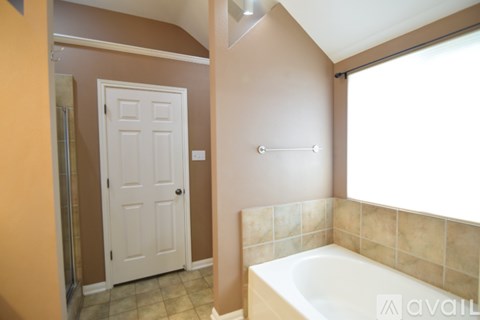 A bathroom with a tub and a door.