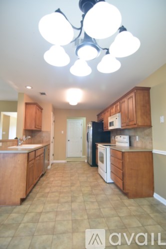 A kitchen with wooden cabinets and a tile floor.