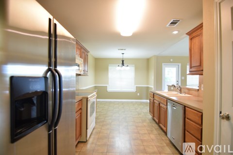 A kitchen with a refrigerator on the left and a sink on the right.