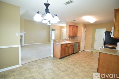 A kitchen with a black fridge and wooden cabinets.