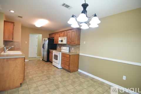 A kitchen with a white sink and brown cabinets.