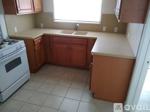 A kitchen with brown cabinets and a white stove.